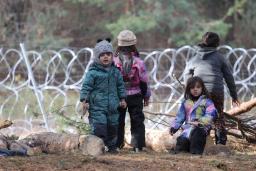 　１２日、ベラルーシのポーランドとの国境地帯で、有刺鉄線近くに集まる子ども（ベルタ通信提供、ロイター＝共同）