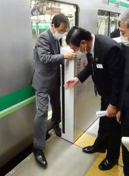 　定位置からずれて停車した列車からホームに降りる斉藤国交相＝１３日午前、東京都江東区の東京メトロの模擬駅