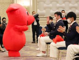 　千葉県のマスコットキャラクター「チーバくん」から副賞を受け取り手を振る柔道男子のウルフ・アロン選手（右手前から２人目）＝１３日午後、千葉市