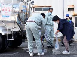 　防災訓練で奈良県の給水車から水を受け取る地元住民（右）＝１４日午前、三重県熊野市