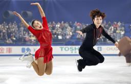 　エキシビションのフィナーレで、ジャンプをして写真に納まる坂本花織（左）と宇野昌磨＝国立代々木競技場