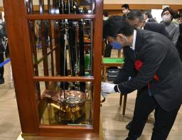 　貨幣が規定を満たす重さで製造されているかをてんびんで調べる高村正大財務政務官＝１５日午前、大阪市の造幣局