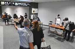 　成田空港で入国者を誘導し証明書などのチェックをする検疫作業＝９月