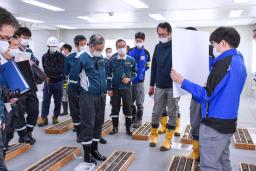 　北陸電力志賀原発の現地調査で、ボーリング調査の試料を確認する原子力規制委の石渡明委員（手前中央）ら＝１８日午後、石川県志賀町