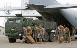 　米海兵隊員とともに、米軍輸送機から降ろされる高機動ロケット砲システム「ハイマース」＝７日午後、青森県八戸市の海上自衛隊八戸航空基地