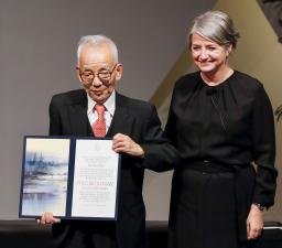 　ノーベル賞授与式で、物理学賞の賞状を受け取った真鍋淑郎・米プリンストン大上席研究員（左）＝６日、米ワシントンの科学アカデミー（共同）