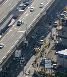 　大型トラックなど２０台以上が絡んだ多重事故の現場（高架下の国道）＝１０日午前１１時２８分、愛知県小牧市（共同通信社ヘリから）
