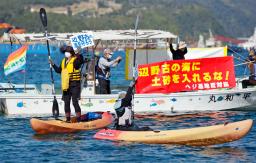 　辺野古沿岸部の埋め立てに抗議し、海上でプラカードを掲げ気勢を上げる反対派の人たち＝１４日午前、沖縄県名護市