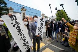 　神戸地裁の判決を受け「不当判決」などと書かれた紙を掲げる弁護士ら＝１６日午後、神戸市
