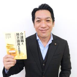 　出版した「介護職よ、地方議員を目指せ！」を手にする千葉県船橋市の宮崎直樹市議