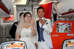 　飛行中のチャーター便の機内で「空の上の結婚式」を挙げた新郎の岩崎晃大さんと新婦の妙さん＝１４日午後