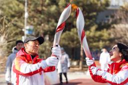 　北京冬季五輪開閉会式の総監督、張芸謀さん（左）。聖火ランナーも務めた＝２日、北京（新華社＝共同）