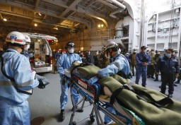 　南海トラフ巨大地震に備えた訓練で、陸自ヘリで海自輸送艦「しもきた」まで搬送された負傷者を救急車へ運ぶ消防隊員＝１５日午前、愛知県蒲郡市