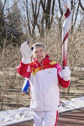 　４日に行われた聖火リレーで、トーチを掲げて走るＩＯＣのバッハ会長＝北京（共同）