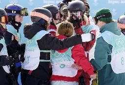 　１５日、女子ビッグエア決勝３回目を終え、各国選手に囲まれる岩渕麗楽（手前右から２人目背中）＝北京（共同）