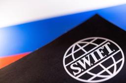 　ＳＷＩＦＴのロゴ（手前）とロシア国旗＝２５日、ボスニア・ヘルツェゴビナ（ロイター＝共同）