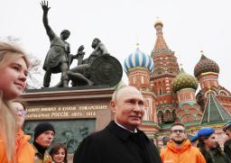 　４日、モスクワの「赤の広場」で、モスクワを解放した英雄の記念碑に献花したロシアのプーチン大統領（中央）（タス＝共同）