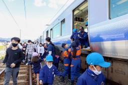 　津波避難訓練で、緊急停止した列車から避難する園児ら＝５日午前、和歌山県広川町