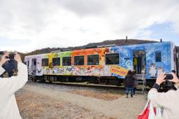　お別れ会で「らぶ」の絵がラッピングされた列車を撮影する参加者＝５日午後、福島県会津若松市の芦ノ牧温泉駅