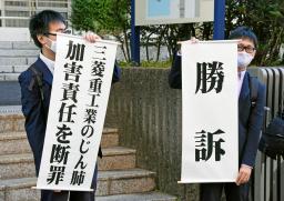 　判決後に「勝訴」などと書かれた垂れ幕を掲げる原告側弁護士＝７日午前、長崎地裁前