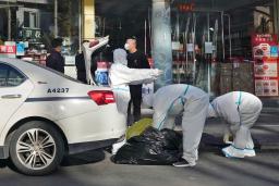 　北京市内の路上で防護服に着替える担当者ら＝４日（共同）