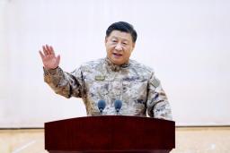 　８日、中国の軍最高指導機関を視察し迷彩服姿で演説する習近平国家主席（新華社＝共同）