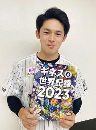 　自身の記録が載った冊子を手にするロッテ・佐々木朗＝１０日（球団提供）