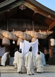 　出雲大社の「神等去出祭」で、神々が宿るとされるサカキを拝殿へ導く神職ら＝１０日午後、島根県出雲市