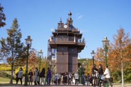 　愛・地球博記念公園を歩く人たち。奥はジブリパーク「青春の丘」エリアの「エレベーター塔」＝９日、愛知県長久手市