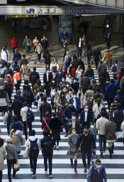 　大阪・梅田の横断歩道を渡るマスク姿の人たち＝１１日午後