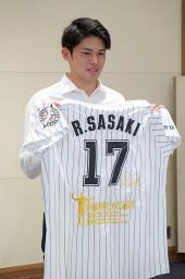 　完全試合の記念ユニホームを持つロッテ・佐々木朗＝１２日、岩手県大船渡市内
