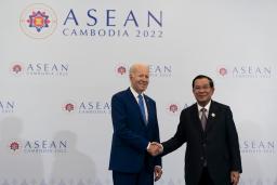 　１２日、カンボジアの首都プノンペンで、フン・セン首相（右）と握手するバイデン米大統領（ＡＰ＝共同）