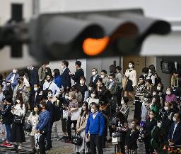 　大阪・梅田の交差点で、信号を待つマスク姿の人たち＝１１日