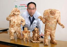 　木材チップで作られた怪獣たちと芳賀省吾さん＝１０月、北海道京極町