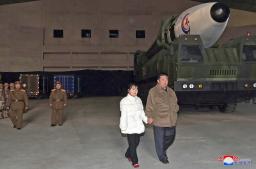 　新型大陸間弾道ミサイル（ＩＣＢＭ）「火星１７」（右奥）を娘（手前左）と現地指導する北朝鮮の金正恩朝鮮労働党総書記＝１８日、平壌国際空港（朝鮮通信＝共同）