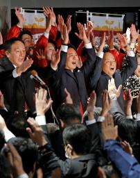 　福岡市長選で４選確実となり、万歳する高島宗一郎氏（中央）＝２０日夜、福岡市