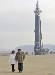 　娘（左）と手をつなぐ北朝鮮の金正恩朝鮮労働党総書記。後方は新型大陸間弾道ミサイル（ＩＣＢＭ）「火星１７」＝１８日、平壌国際空港（朝鮮通信＝共同）