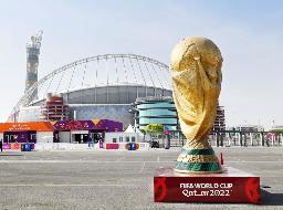 　ハリファ国際競技場（奥）付近に設置されたサッカーＷ杯の優勝トロフィーのオブジェ＝１８日、ドーハ