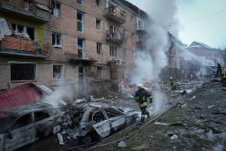　２３日、ロシアの砲撃を受けたウクライナの首都キーウ郊外で、消火活動に当たる消防隊員ら（ＡＰ＝共同）