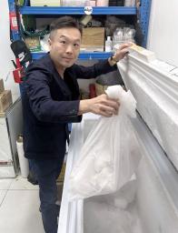 　日本産の冷凍マグロを手にする高俊傑氏＝１７日、香港（共同）