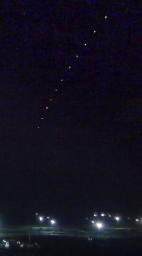 　北朝鮮・東倉里の西海衛星発射場の方向から上昇する飛翔体＝２４日未明、中国遼寧省東港から撮影（３秒おきに撮影した１１枚を比較明合成、共同）
