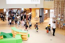 　完成した「学び舎ゆめの森」の校舎に入る子どもたち＝２５日午前、福島県大熊町