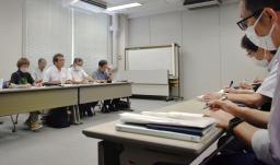 　中国電力の担当者（右）と面会する、中間貯蔵施設建設計画に反対する市民団体のメンバー＝２５日、広島市