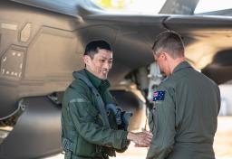 　オーストラリア北部準州のティンダル空軍基地に到着し、出迎えを受ける航空自衛隊員（左）＝２６日（オーストラリア国防省提供・共同）