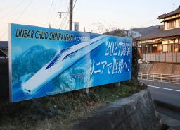 　リニア中央新幹線の新駅の工事が進められている岐阜県中津川市に置かれた２０２７年開業を伝える看板＝２９日午後