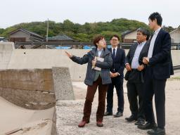 　石川県輪島市内の隆起した海岸を視察する地方創生支援官の（左から）佐藤由紀子さん、加藤太郎さん、坂本和也さん＝２６日午後