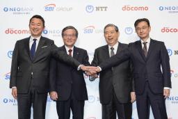 　記者会見で写真に納まるＮＴＴドコモの前田義晃社長（左端）、ＳＢＩＨＤの北尾吉孝会長兼社長（左から３人目）ら＝２９日午後、東京都内のホテル