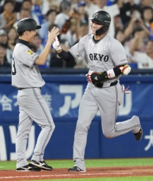 　１１回、勝ち越しソロを放ち、コーチとタッチを交わす巨人・坂本（右）＝横浜