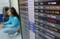 　欠航や遅延などの運航状況を示す米ロサンゼルス国際空港の発着案内板＝１２日（ゲッティ＝共同）