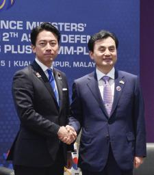 　会談で握手する小泉防衛相（左）と韓国の安圭伯国防相＝１日、クアラルンプール（共同）